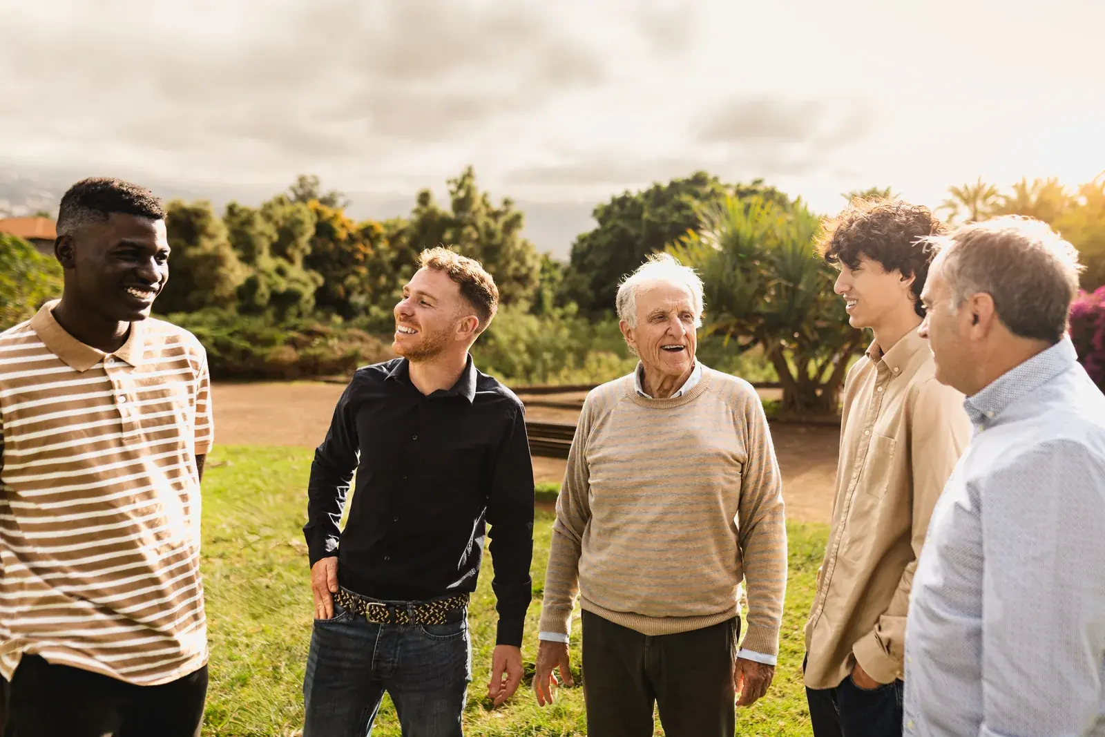 Five men of different ages standing and talking together outdoors